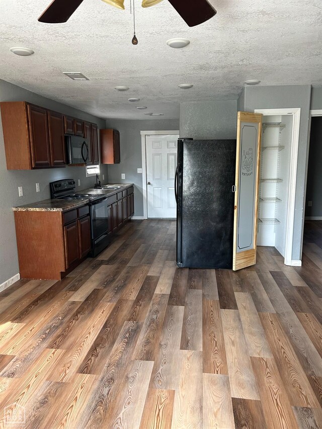 2209 Central St, Jonesboro, AR 72401 - kitchen with baseboards, a sink, a textured ceiling, dark wood-style floors, and black appliances
