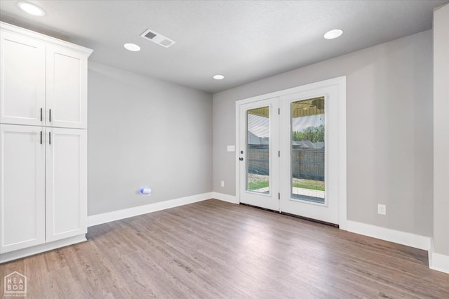 spare room with visible vents, light wood finished floors, and baseboards