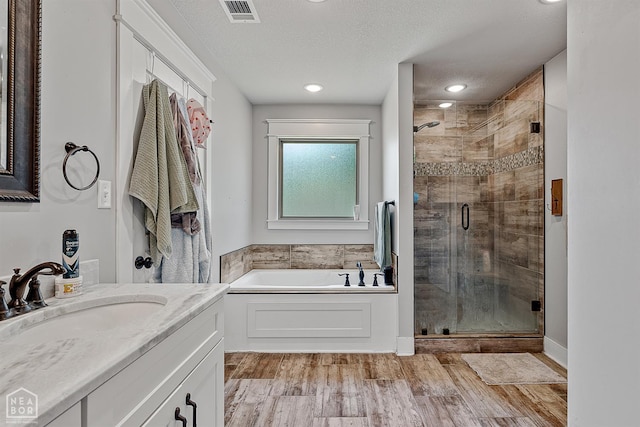 4317 Cypress Pointe Ln, Jonesboro, AR 72405 - full bath featuring a garden tub, a stall shower, vanity, wood finished floors, and a textured ceiling