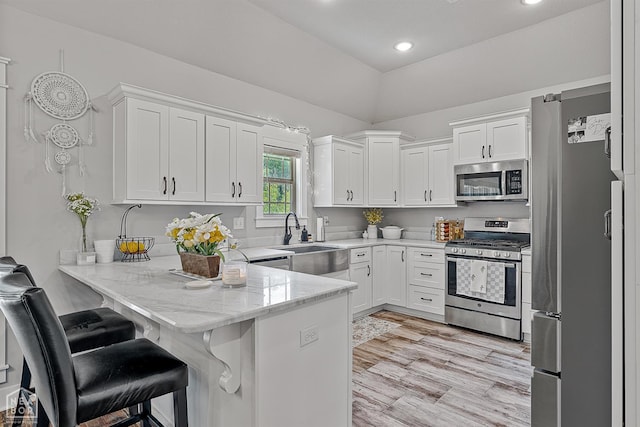 4317 Cypress Pointe Ln, Jonesboro, AR 72405 - kitchen featuring stainless steel appliances, a peninsula, white cabinets, light stone counters, and recessed lighting