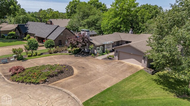 106 Winston Pl, Paragould, AR 72450 - view of front of home featuring concrete driveway, an attached garage, a chimney, roof with shingles, and a front yard