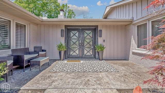 106 Winston Pl, Paragould, AR 72450 - view of exterior entry featuring a chimney, a patio area, and board and batten siding