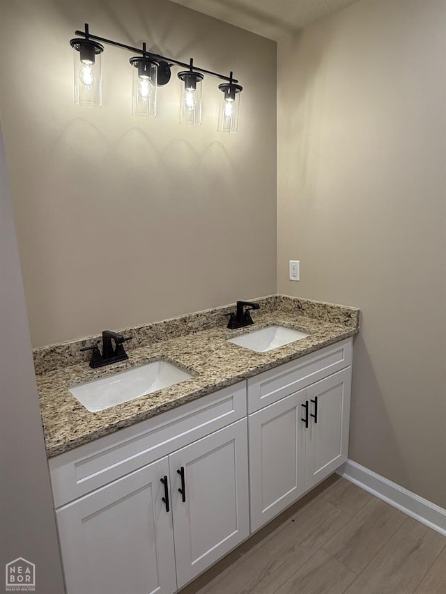 5709 Morgan Dr, Jonesboro, AR 72401 - bathroom featuring double vanity, wood finished floors, and baseboards