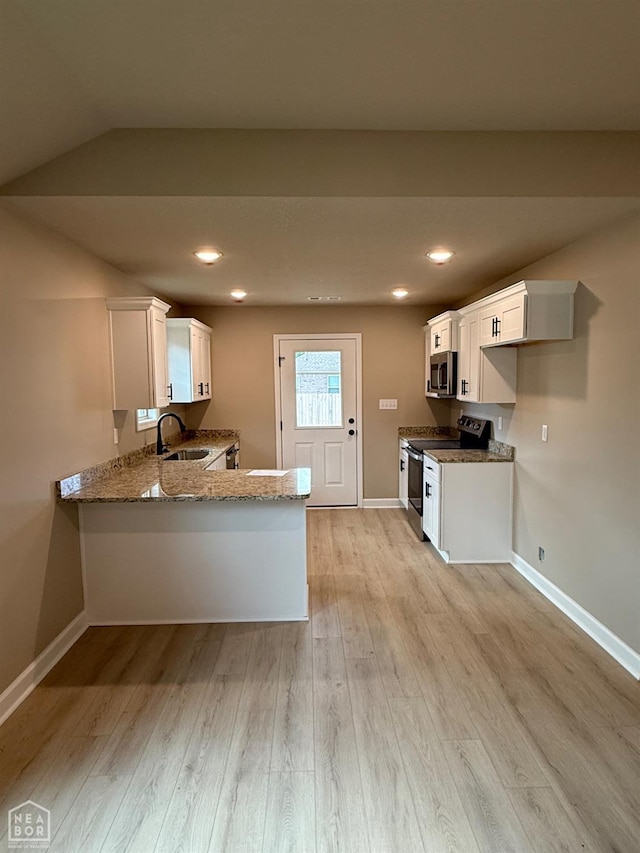5709 Morgan Dr, Jonesboro, AR 72401 - kitchen featuring stainless steel appliances, a sink, light stone countertops, light wood-style flooring, and a peninsula