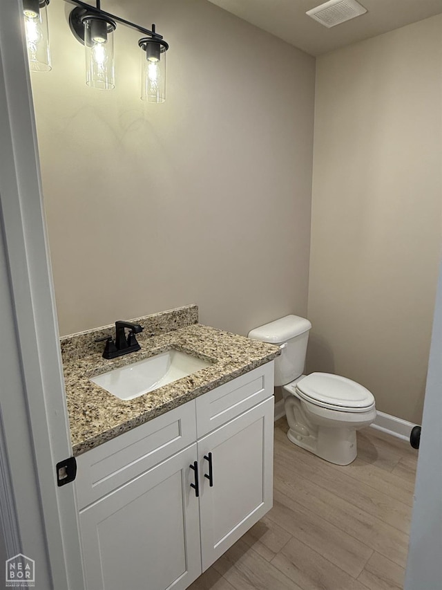 5709 Morgan Dr, Jonesboro, AR 72401 - bathroom with vanity, toilet, wood finished floors, and baseboards