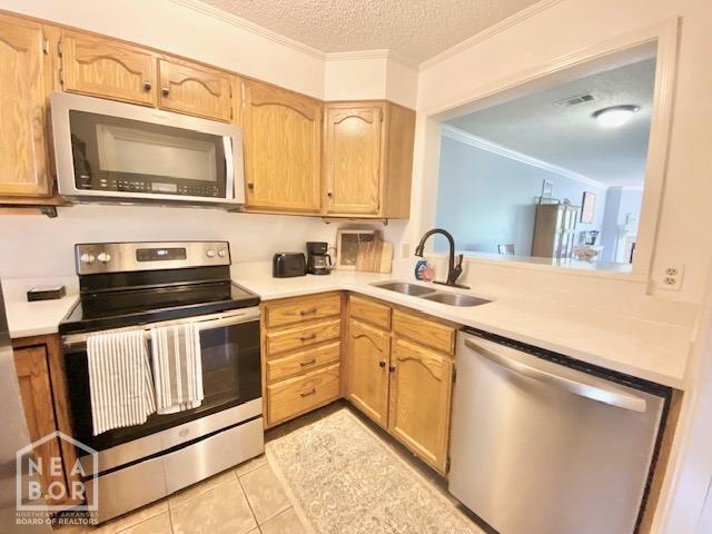 1300 S Church St, Jonesboro, AR 72401 - kitchen featuring crown molding, stainless steel appliances, a sink, and light countertops