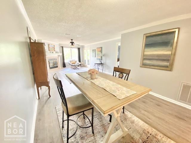1300 S Church St, Jonesboro, AR 72401 - dining space featuring crown molding, visible vents, light wood-type flooring, a textured ceiling, and a ceiling fan
