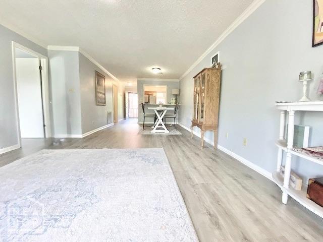 1300 S Church St, Jonesboro, AR 72401 - interior space featuring crown molding, a textured ceiling, baseboards, and wood finished floors