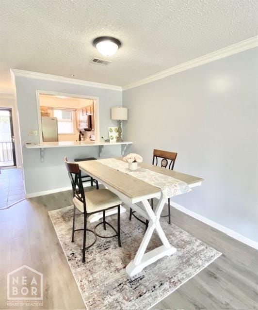1300 S Church St, Jonesboro, AR 72401 - dining room with a textured ceiling, visible vents, ornamental molding, and wood finished floors