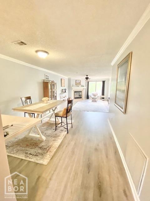1300 S Church St, Jonesboro, AR 72401 - dining area featuring visible vents, crown molding, wood finished floors, baseboards, and a glass covered fireplace