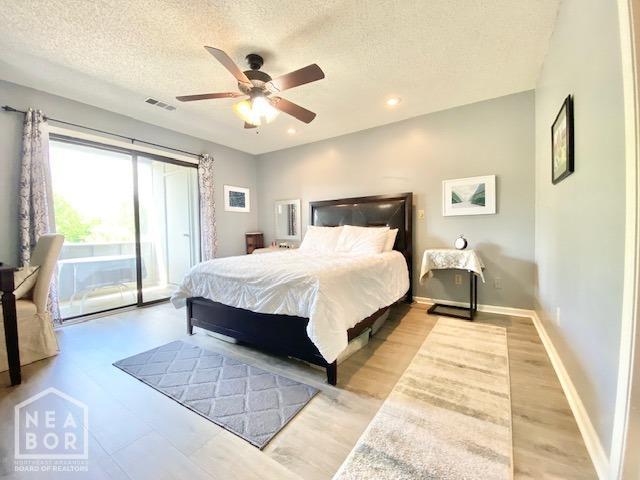 1300 S Church St, Jonesboro, AR 72401 - bedroom with a textured ceiling, access to exterior, visible vents, baseboards, and light wood-style flooring