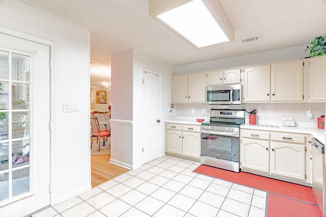 1207 Hunters Run Cv, Jonesboro, AR 72401 - kitchen with appliances with stainless steel finishes, light countertops, tasteful backsplash, white cabinetry, and baseboards