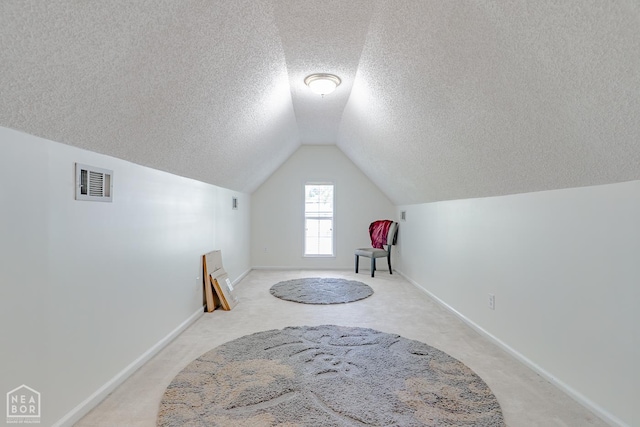 1207 Hunters Run Cv, Jonesboro, AR 72401 - bonus room featuring a textured ceiling, vaulted ceiling, light colored carpet, and baseboards