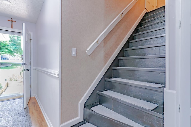 1207 Hunters Run Cv, Jonesboro, AR 72401 - stairs featuring a textured ceiling, carpet, and baseboards