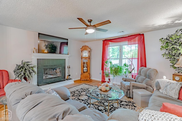 1207 Hunters Run Cv, Jonesboro, AR 72401 - living area featuring wood finished floors, ceiling fan, a textured ceiling, and a fireplace