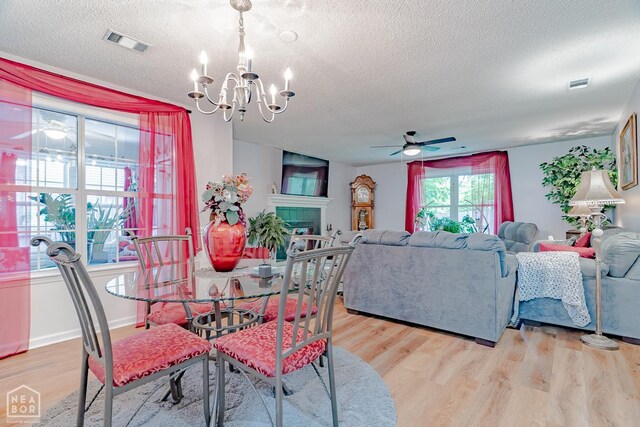 1207 Hunters Run Cv, Jonesboro, AR 72401 - dining room featuring a textured ceiling, ceiling fan, a chandelier, and light wood-style flooring