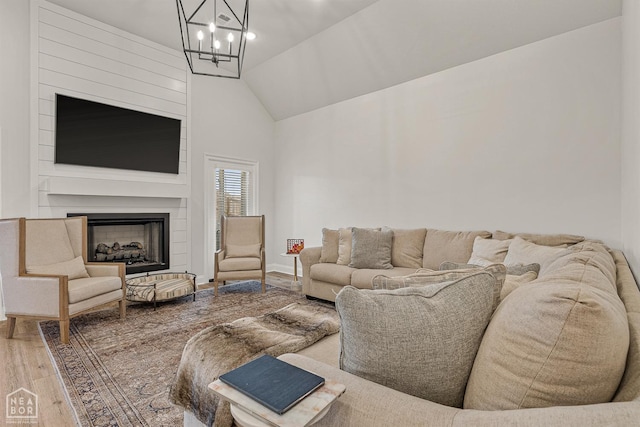 107 Hidden Creek St, Brookland, AR 72417 - living room with a chandelier, wood finished floors, a fireplace, and high vaulted ceiling
