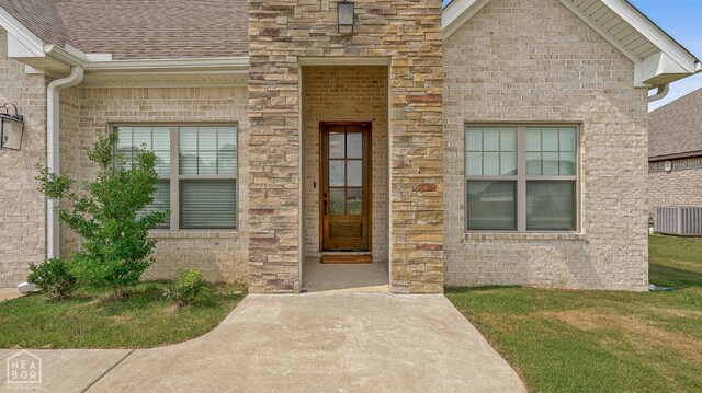 107 Hidden Creek St, Brookland, AR 72417 - entrance to property featuring central air condition unit, roof with shingles, a yard, and a patio area