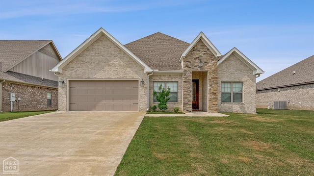 107 Hidden Creek St, Brookland, AR 72417 - traditional home with a garage, driveway, a front yard, central AC unit, and stone siding