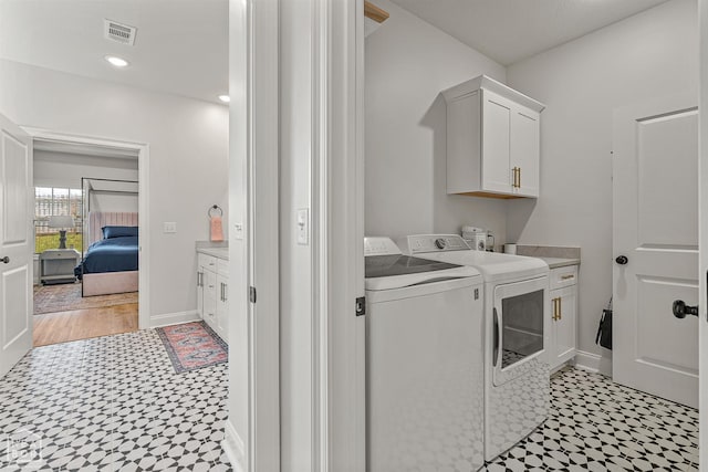 107 Hidden Creek St, Brookland, AR 72417 - laundry area featuring light floors, separate washer and dryer, cabinet space, and baseboards