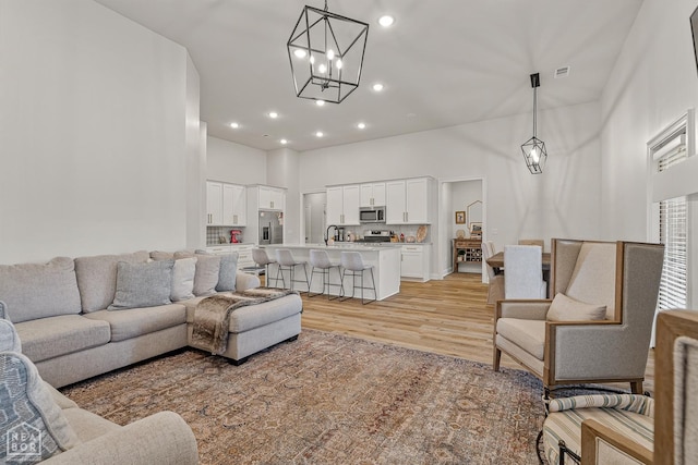 107 Hidden Creek St, Brookland, AR 72417 - living area with a chandelier, light wood finished floors, a high ceiling, and recessed lighting