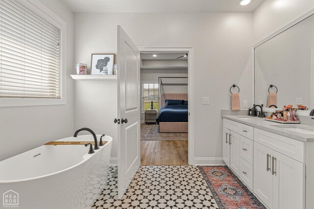 107 Hidden Creek St, Brookland, AR 72417 - bathroom featuring double vanity, a soaking tub, ensuite bathroom, recessed lighting, and baseboards