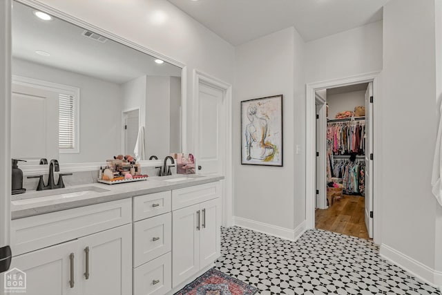 107 Hidden Creek St, Brookland, AR 72417 - bathroom featuring double vanity, tile patterned floors, baseboards, a walk in closet, and recessed lighting