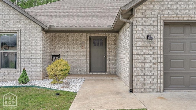 2100 N 29th St, Paragould, AR 72450 - view of exterior entry featuring brick siding, a garage, and roof with shingles