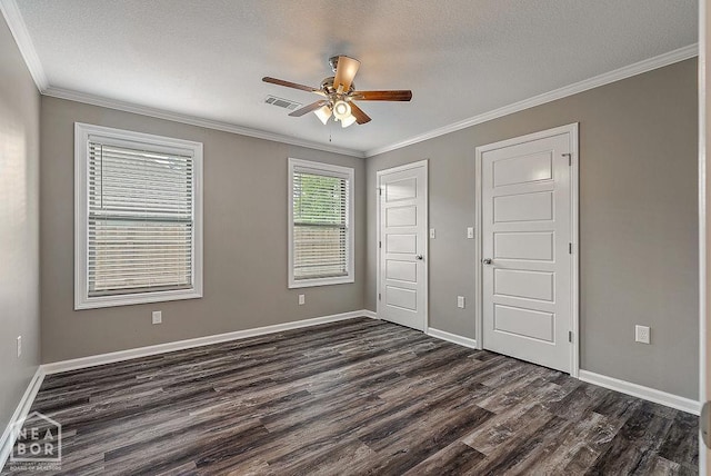 2100 N 29th St, Paragould, AR 72450 - unfurnished bedroom featuring crown molding, baseboards, dark wood-style floors, and visible vents