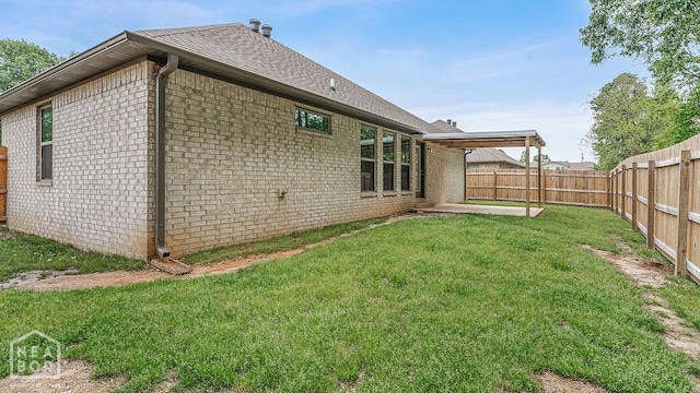 2100 N 29th St, Paragould, AR 72450 - rear view of property featuring a shingled roof, brick siding, a fenced backyard, a patio area, and a lawn