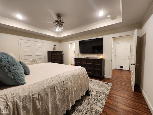 bedroom with a raised ceiling, crown molding, baseboards, and dark wood-style floors