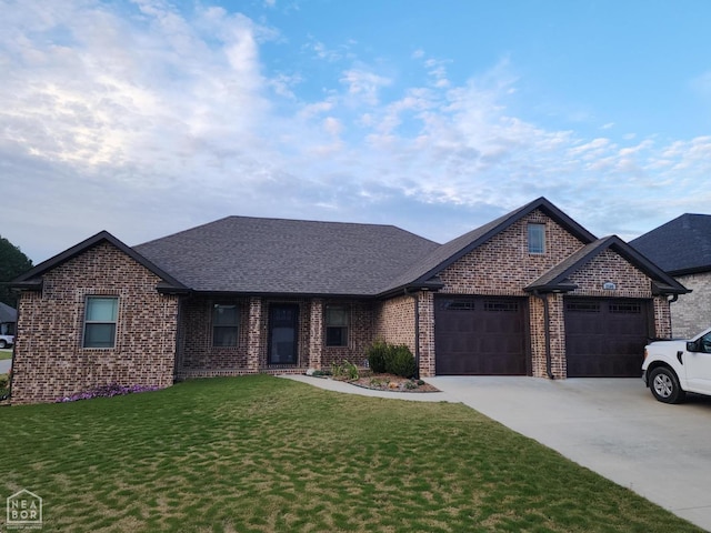 view of front facade featuring driveway, a front yard, brick siding, a garage, and a shingled roof