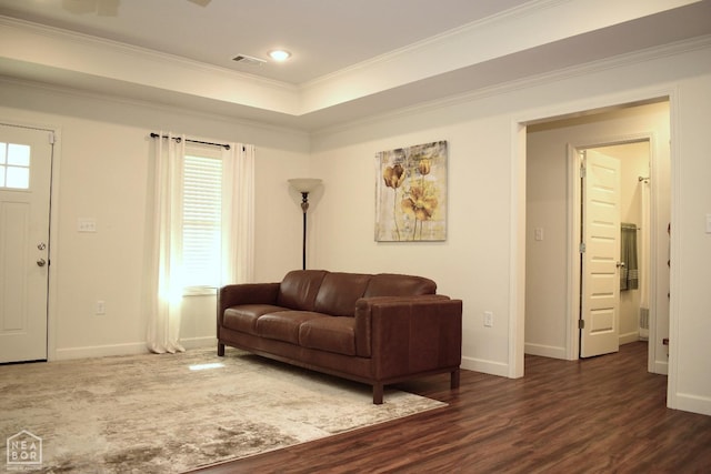 living area featuring visible vents, baseboards, ornamental molding, and dark wood-style floors