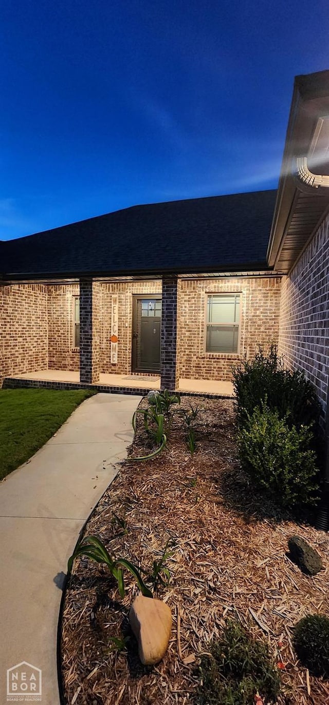 view of exterior entry with brick siding