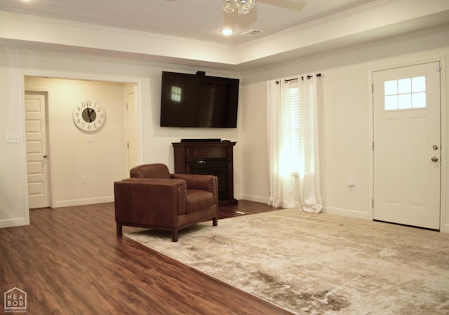 entrance foyer featuring baseboards, crown molding, a tray ceiling, ceiling fan, and wood finished floors