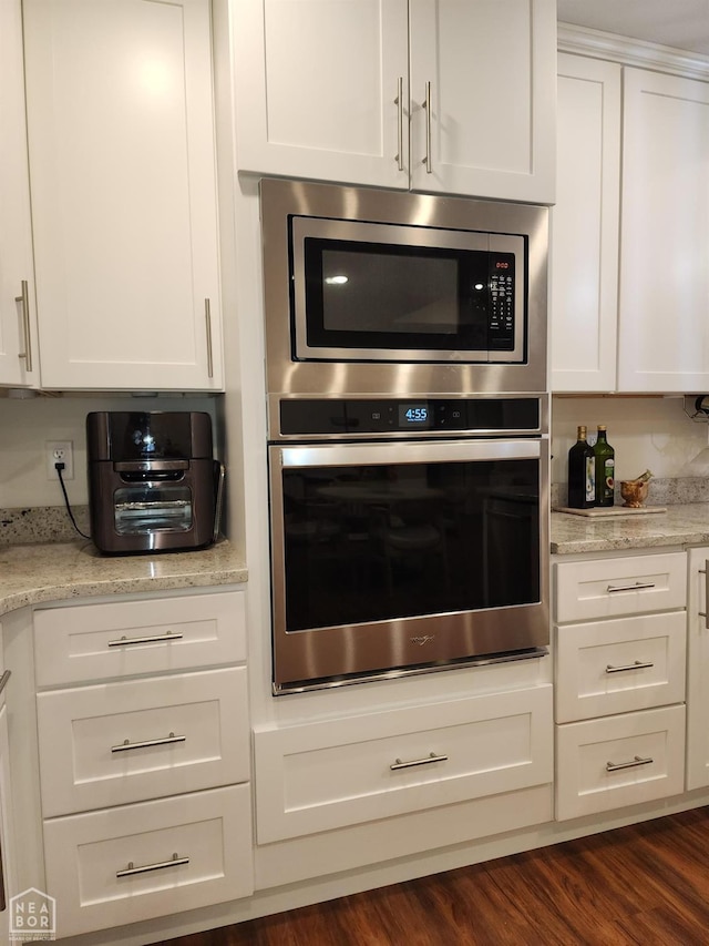 kitchen featuring stainless steel appliances, white cabinets, and dark wood-style flooring