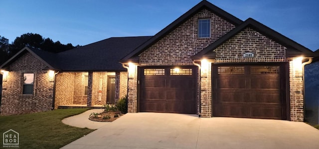 view of front of home with brick siding, a garage, and concrete driveway