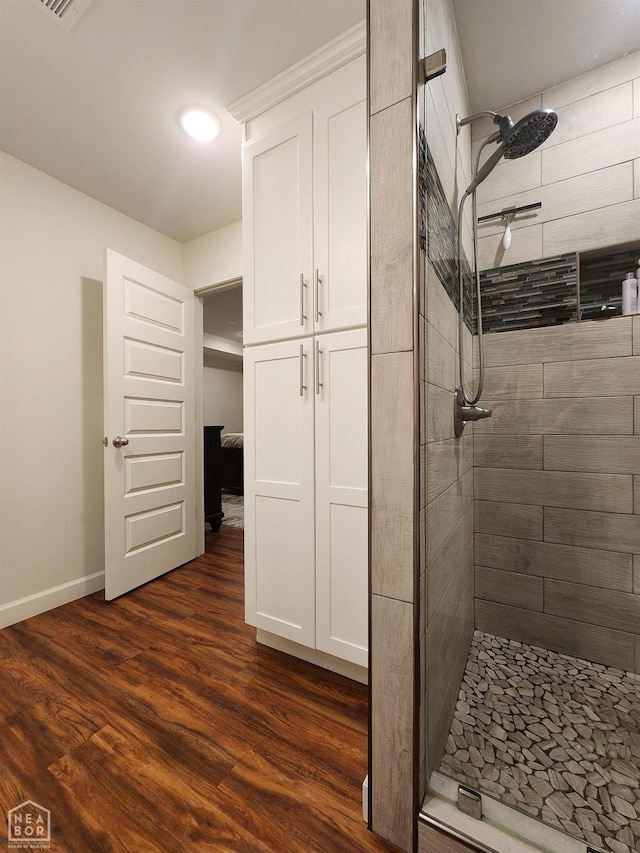 bathroom featuring baseboards, a stall shower, and wood finished floors