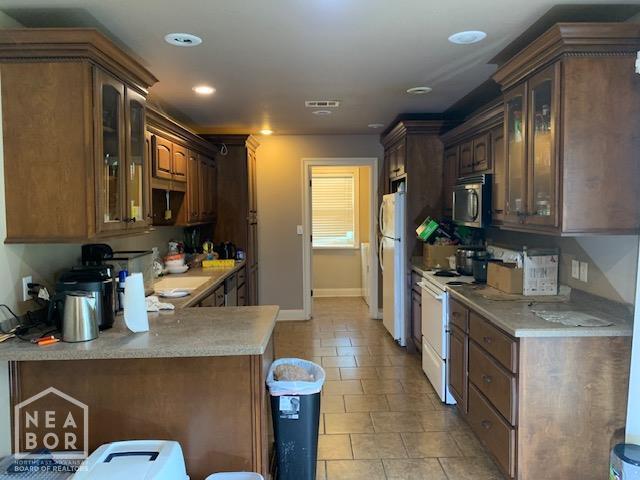 4709 Summit Ridge Dr, Jonesboro, AR 72404 - kitchen featuring white appliances, glass insert cabinets, light countertops, baseboards, and recessed lighting