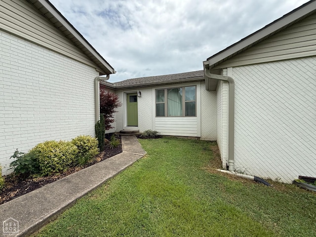 1354 Wiley Dr, Piggott, AR 72454 - doorway to property with a lawn and brick siding