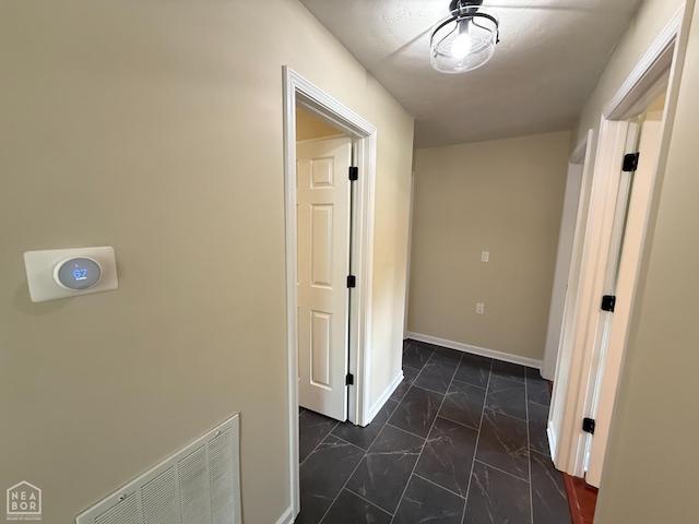 1354 Wiley Dr, Piggott, AR 72454 - hall featuring dark marble finish flooring and baseboards