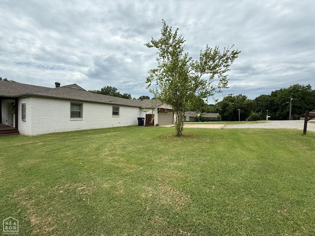 1354 Wiley Dr, Piggott, AR 72454 - view of grassy yard with concrete driveway and a garage