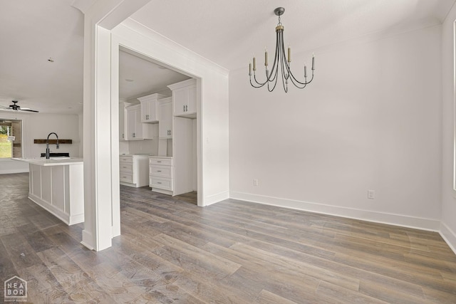 3428 Hudson Dr, Jonesboro, AR 72405 - unfurnished dining area with crown molding, wood finished floors, a sink, and baseboards