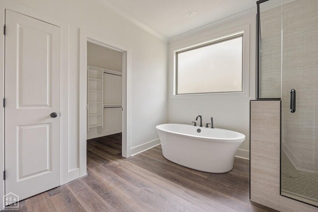 3428 Hudson Dr, Jonesboro, AR 72405 - bathroom featuring baseboards, a freestanding tub, ornamental molding, wood finished floors, and a stall shower
