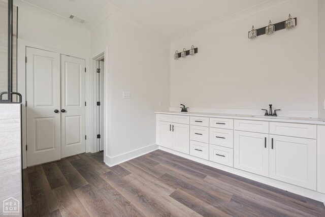 3428 Hudson Dr, Jonesboro, AR 72405 - interior space featuring dark wood-type flooring, ornamental molding, visible vents, a sink, and baseboards