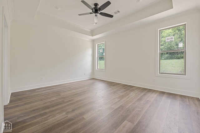 3428 Hudson Dr, Jonesboro, AR 72405 - empty room with visible vents, a tray ceiling, and wood finished floors