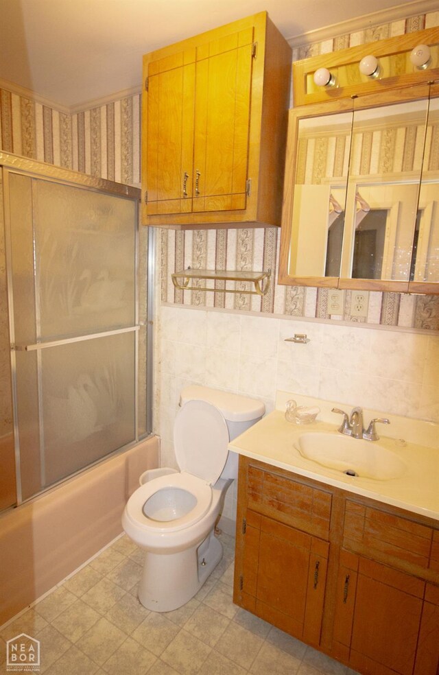 805 James Ln, Trumann, AR 72472 - full bathroom with vanity, bath / shower combo with glass door, and tile walls