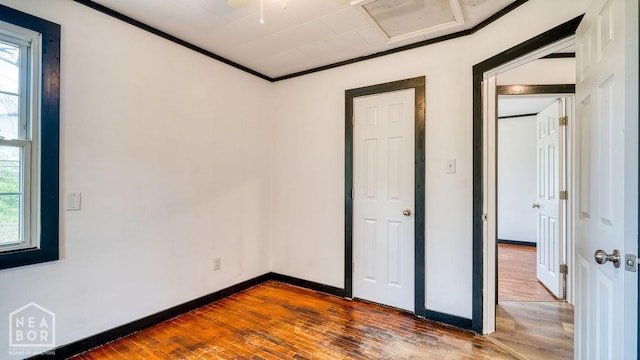 1205 Sims Ave, Jonesboro, AR 72401 - unfurnished bedroom with hardwood / wood-style floors, multiple windows, baseboards, and crown molding