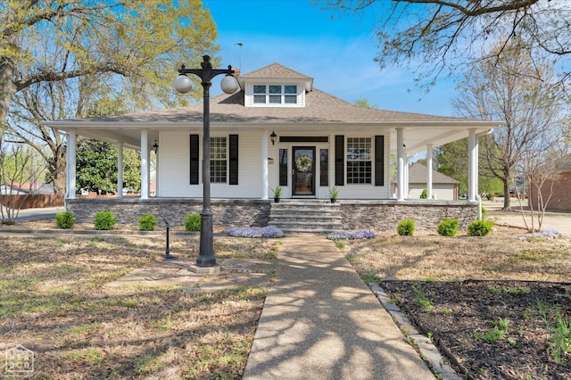 farmhouse inspired home with a shingled roof and covered porch
