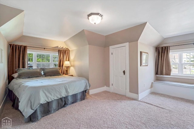bedroom with carpet floors, baseboards, and vaulted ceiling